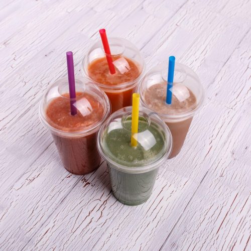 Four colorful, useful and healthy smoothies in plastic cups